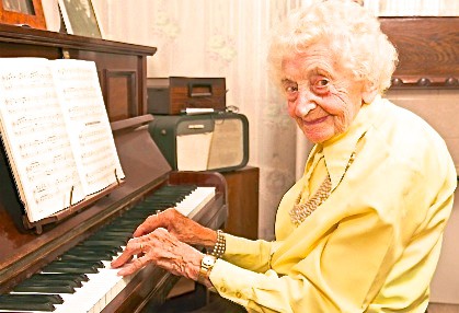 Senior woman playing the piano and enjoying benefits of Music Therapy